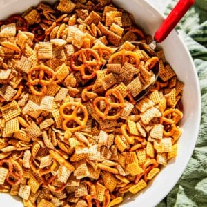 homemade chex mix in a large bowl with a metal, red-handled scoop