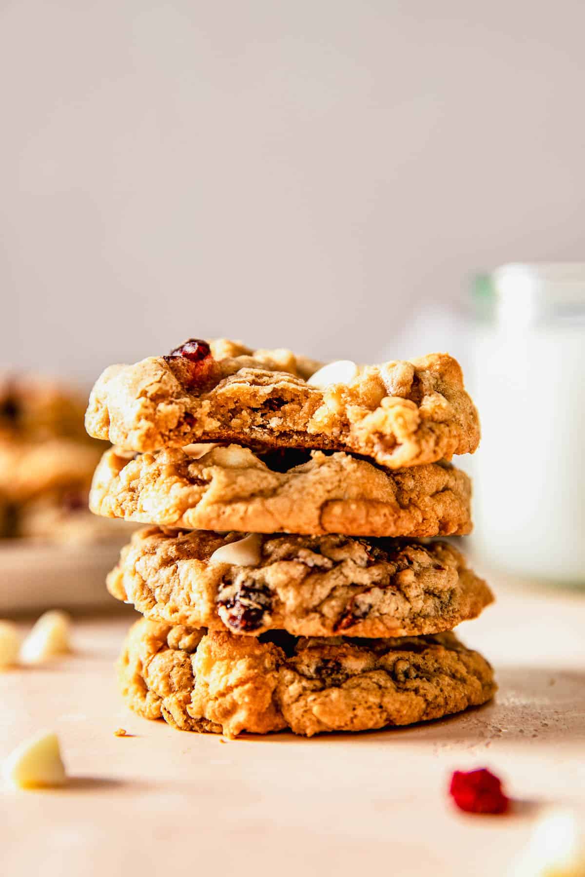a stack of four white chocolate cranberry cookies with a bite out of the top cookie