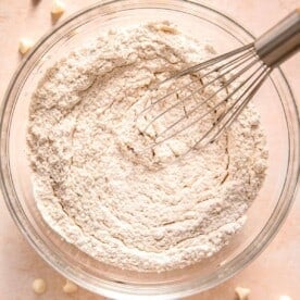 metal whisk in a clear bowl with dry ingredients