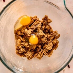 two eggs and sugar mixture in a clear stand mixer bowl