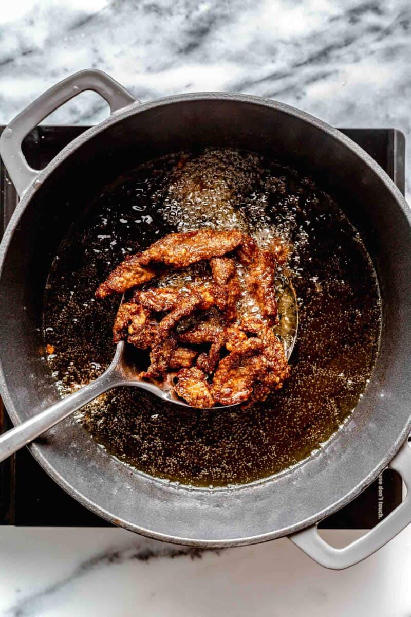 Frying strips of beef.