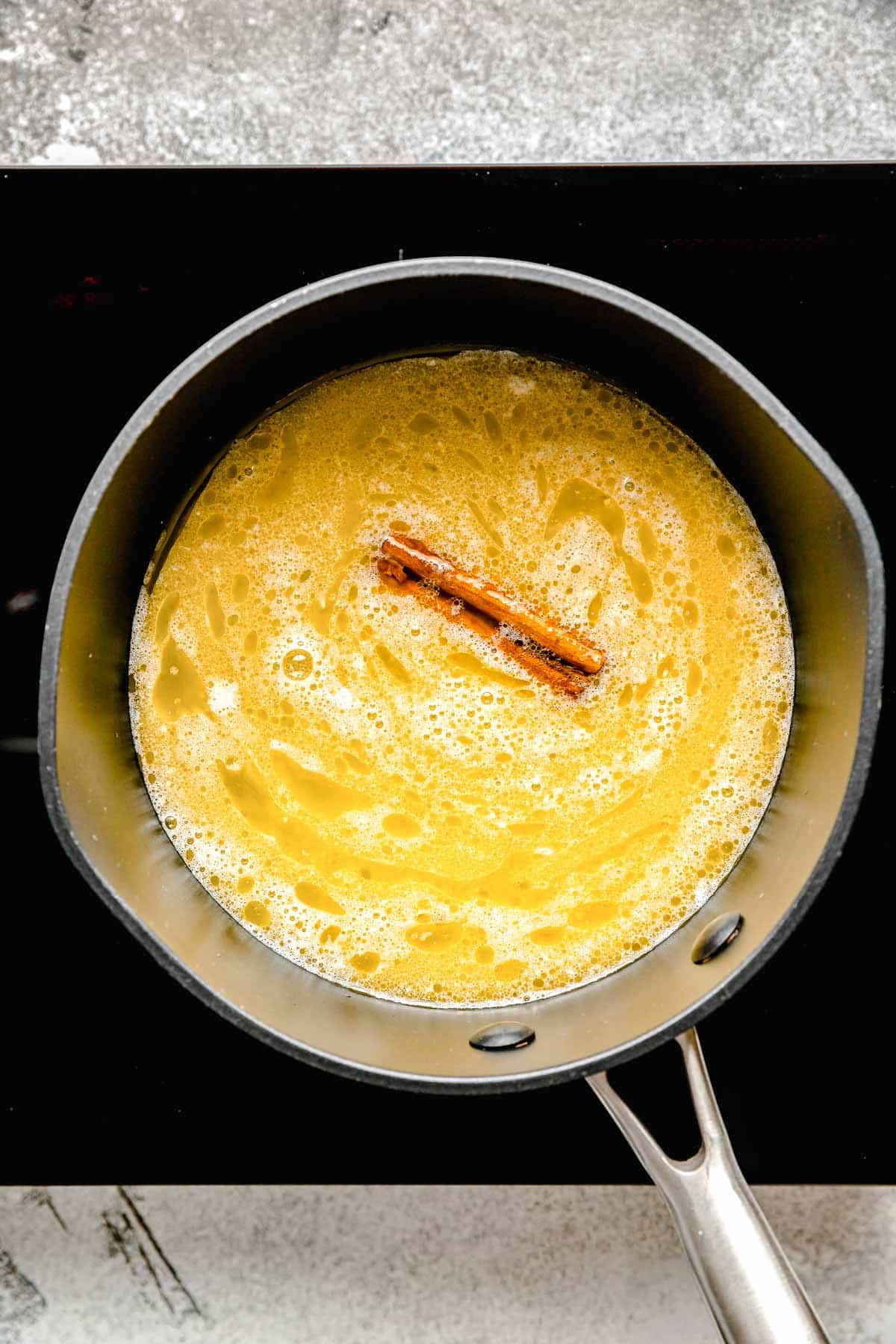 melted butter and a cinnamon stick in a saucepot