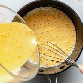 Whisking tempered egg yolks into custard for ice cream.