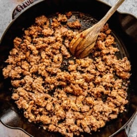 Browning Italian sausage in a skillet.