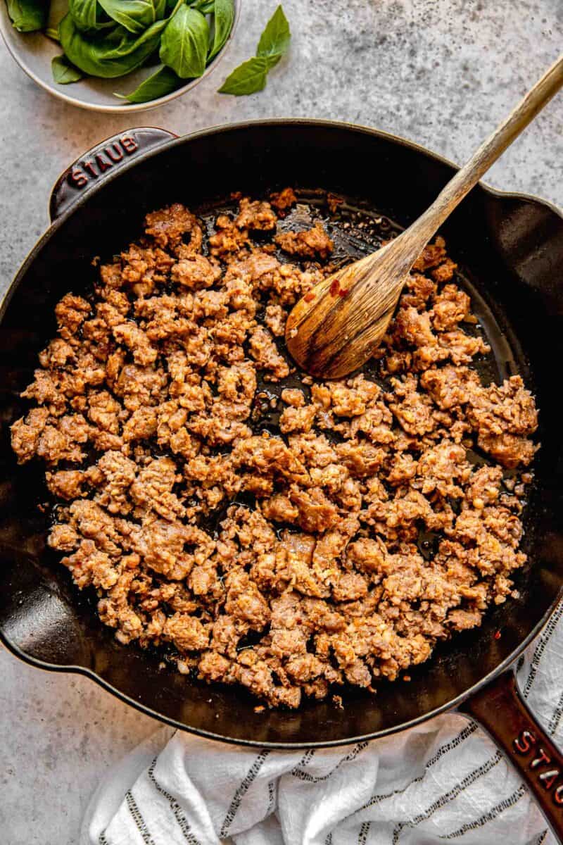 Browning Italian sausage in a skillet.