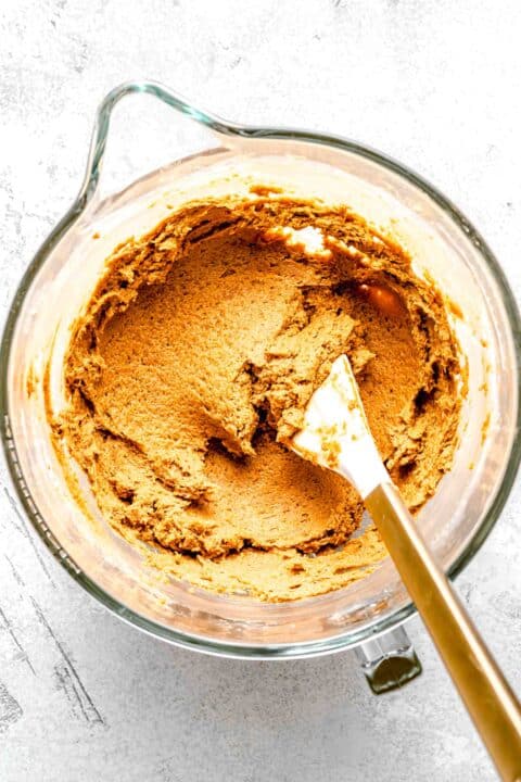 butter and sugar creamed together in a clear stand mixer bowl with white spatula