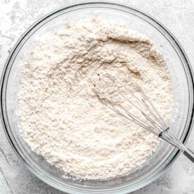 flour mixture in a clear bowl with whisk