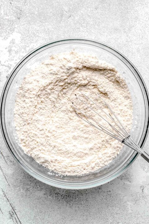 flour mixture in a clear bowl with whisk