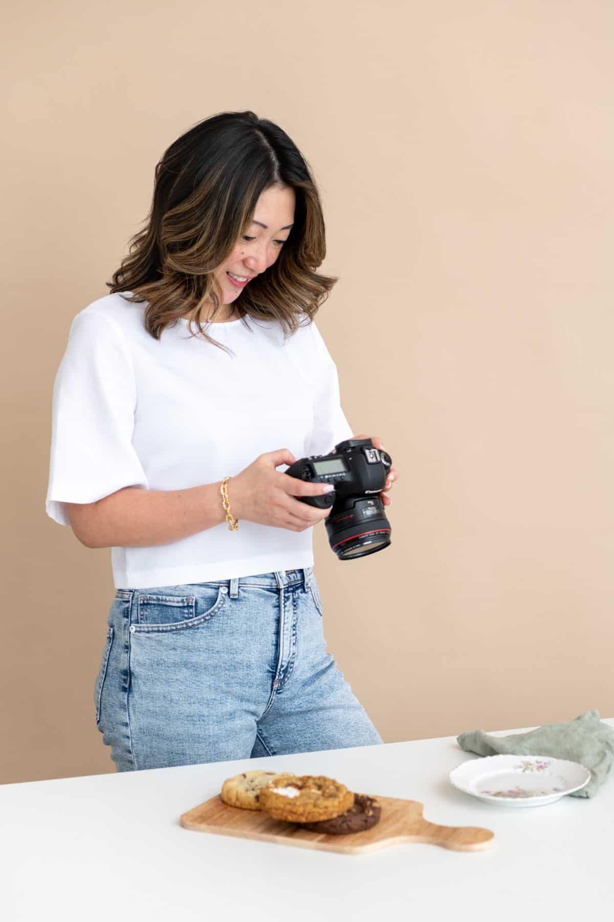 Julie Chiou holding a camera and looking at it