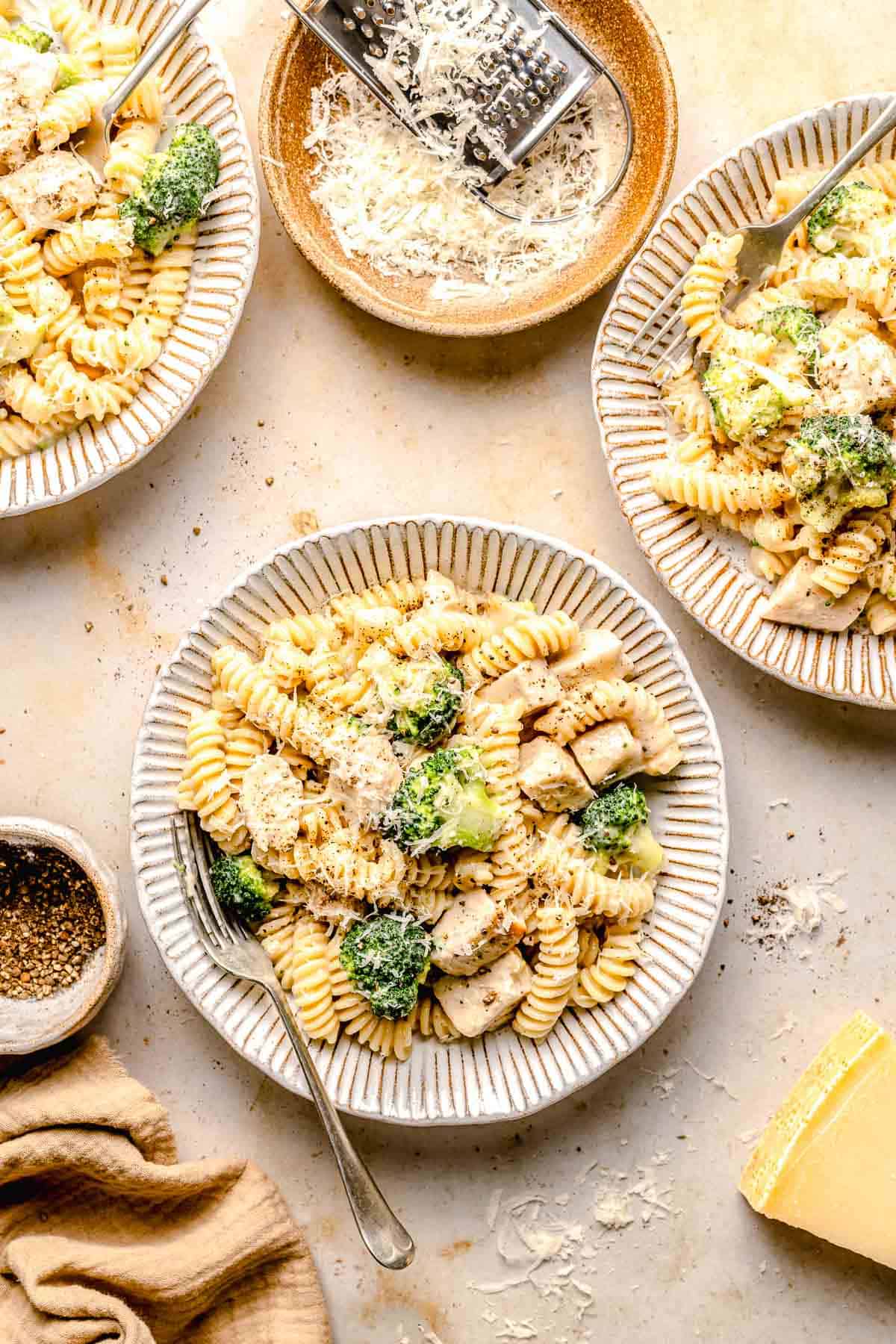 Overhead image of chicken broccoli Alfredo pasta served in bowls.