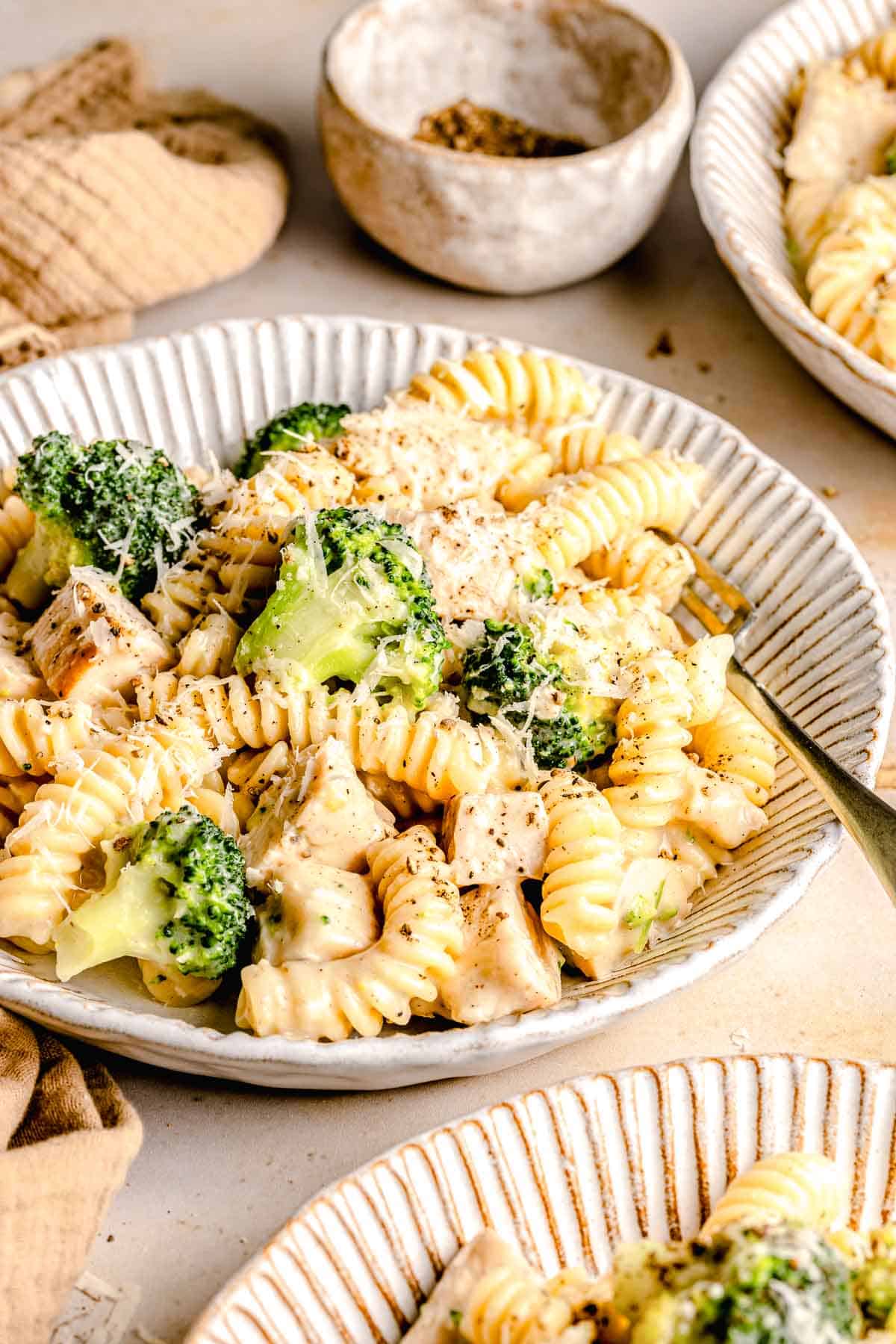 Chicken broccoli Alfredo pasta in a bowl with a fork.