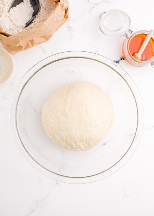 bagel dough in a clear bowl