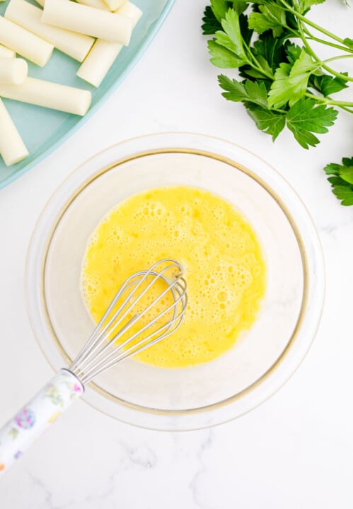 whisking eggs in a clear bowl
