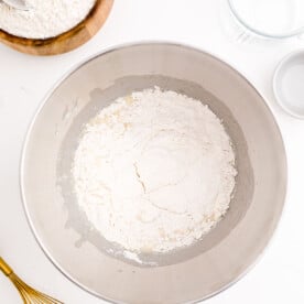 flour added to a metal bowl of a stand mixer