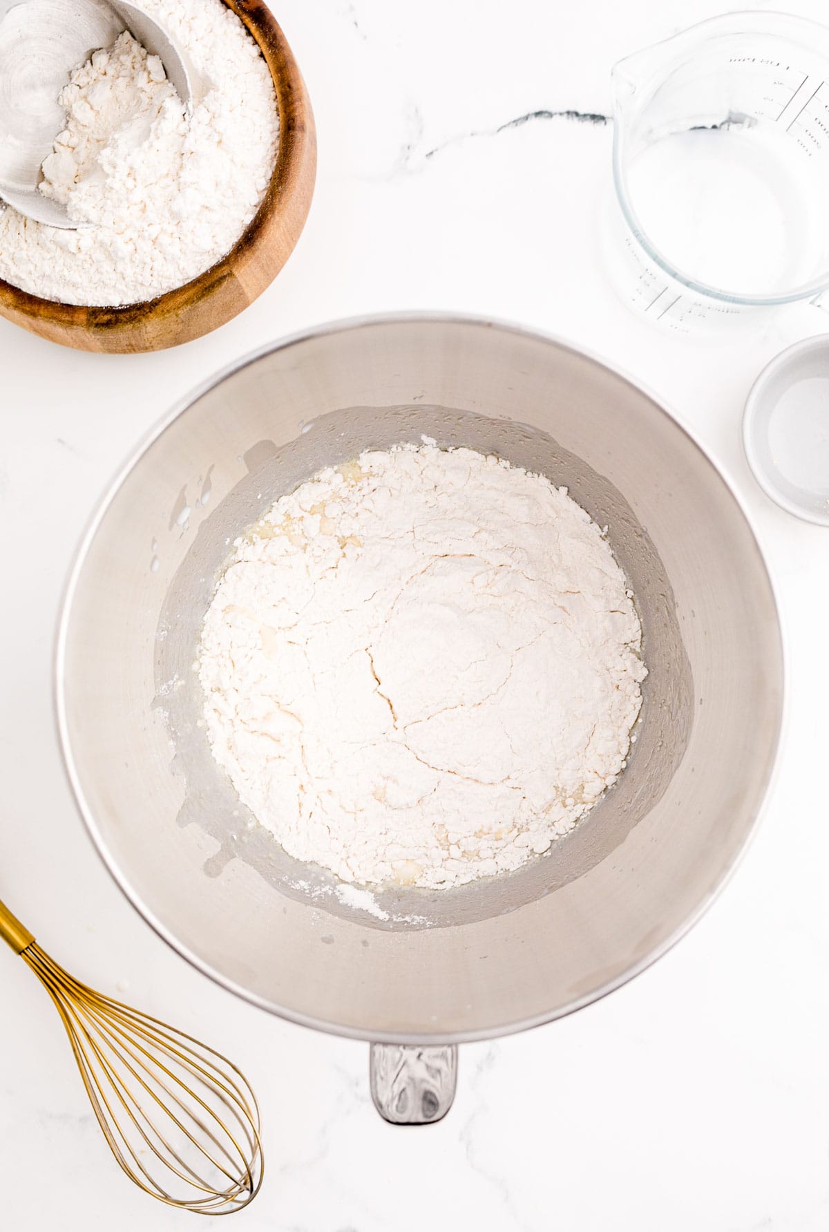 flour added to a metal bowl of a stand mixer