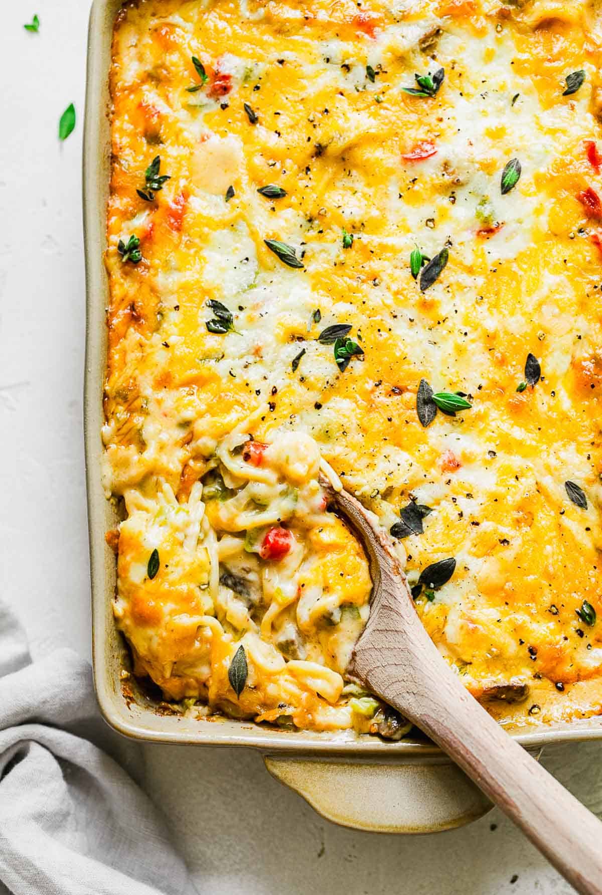 a wooden spoon scooping into the spaghetti casserole