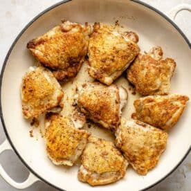 Searing chicken in a pan.