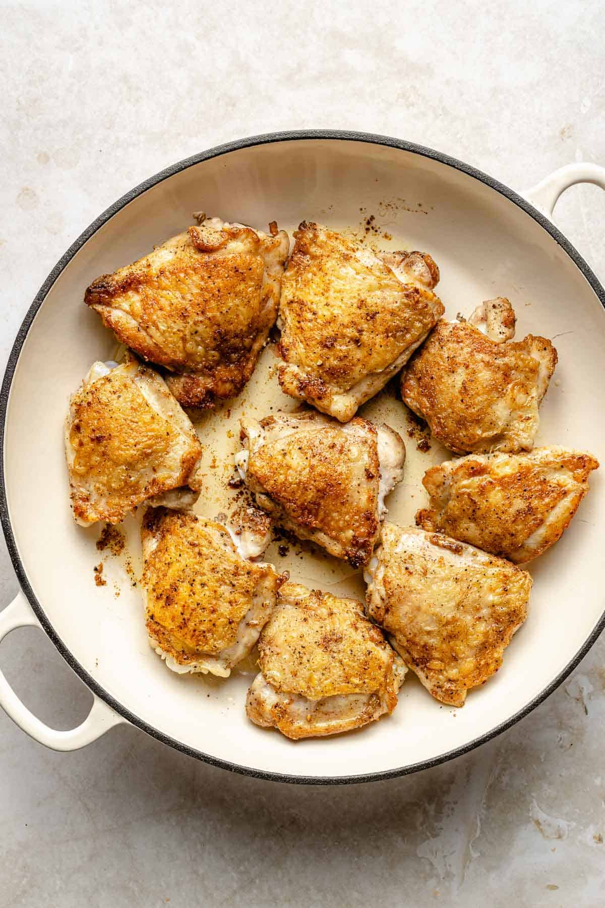 Searing chicken in a pan.