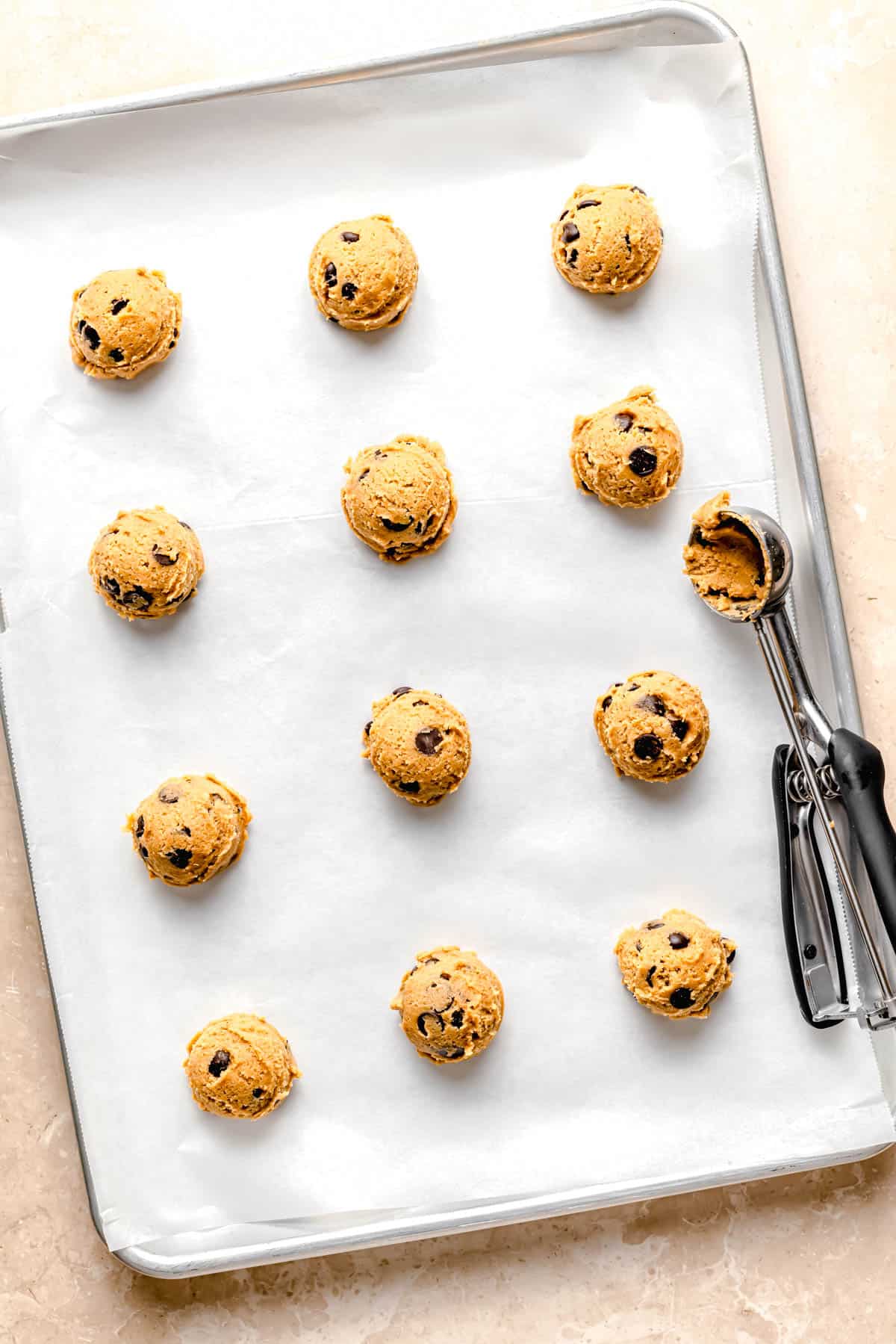 balls of cookie dough are spread out on a baking sheet