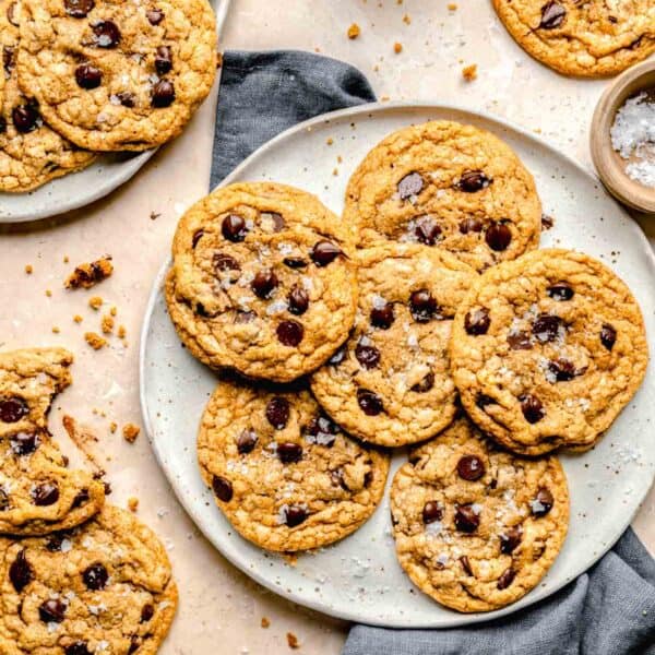 a batch of cookies is presented on a plate with a tea towel next to it