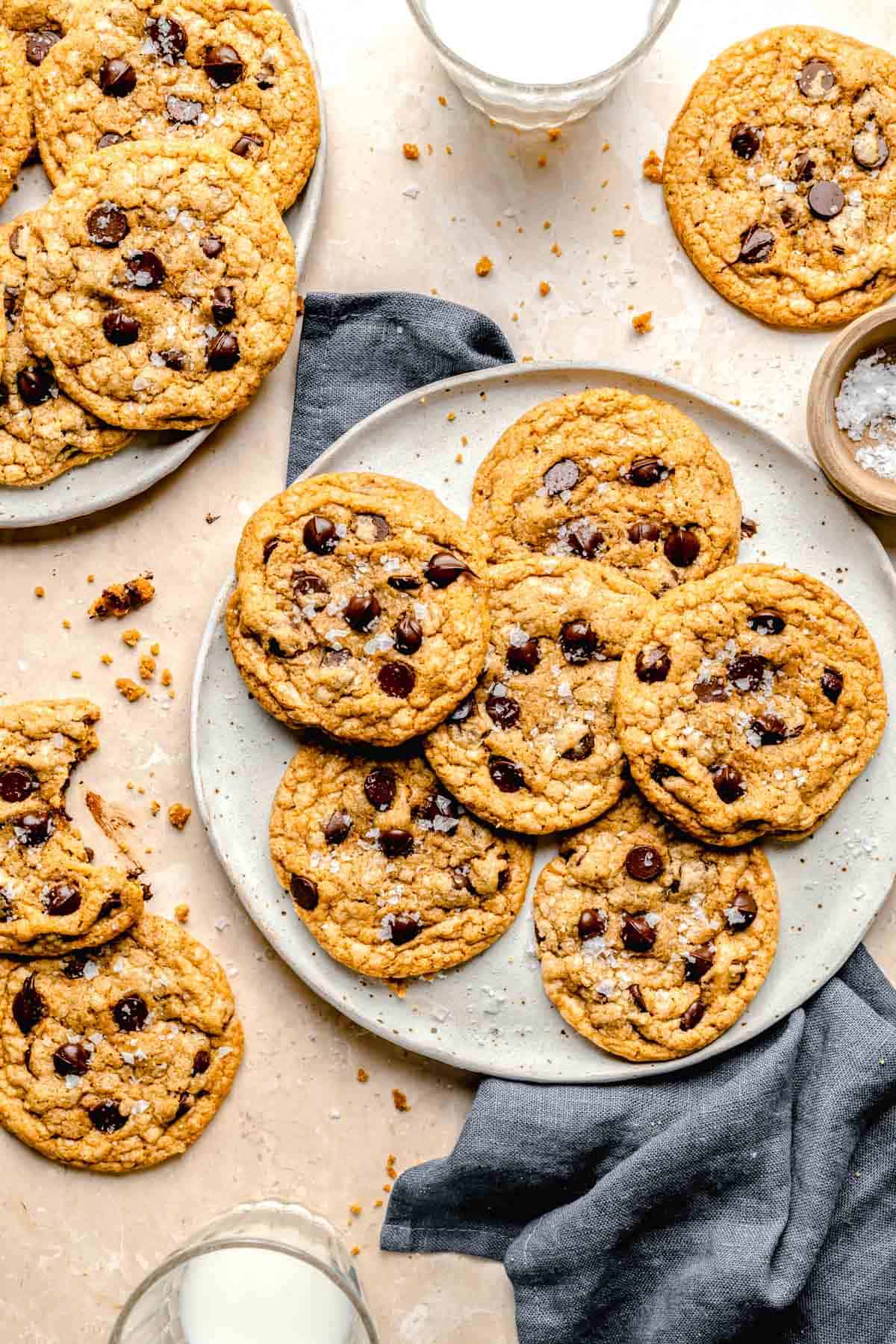 a batch of cookies is presented on a plate with a tea towel next to it