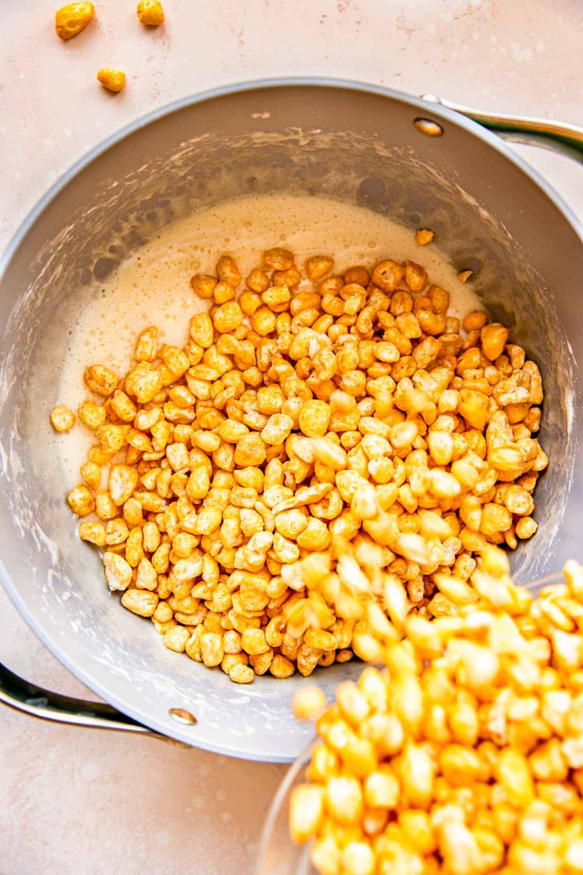 Corn Pops cereal is being added to a pan. 