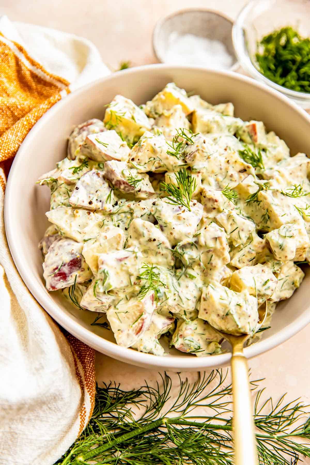 A bowl is filled with creamy dill potato salad.