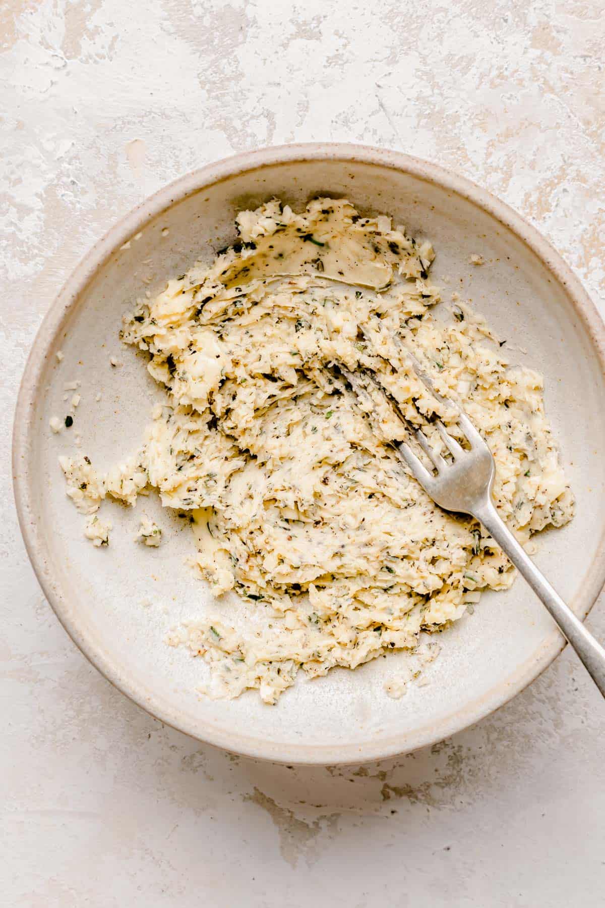 the butter mixture is being combined with a fork in a bowl