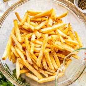 Fries are presented in a glass bowl.