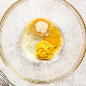 The ingredients for the honey mustard mixture are in a glass bowl.