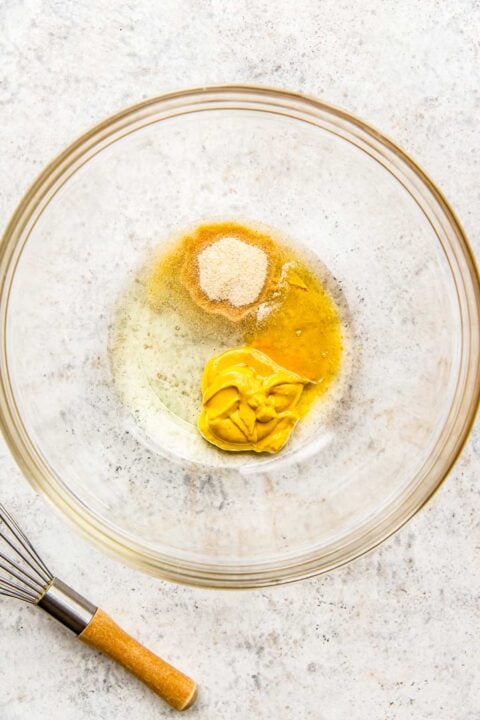 The ingredients for the honey mustard mixture are in a glass bowl.