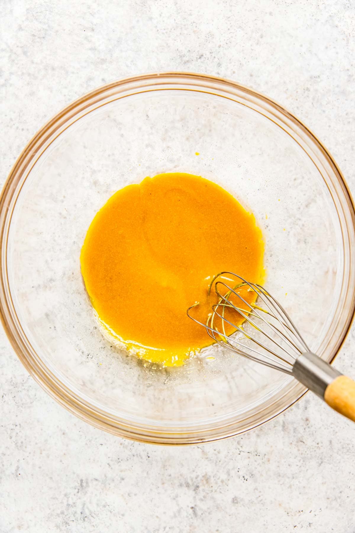 A whisk has combine the honey mustard ingredients. 