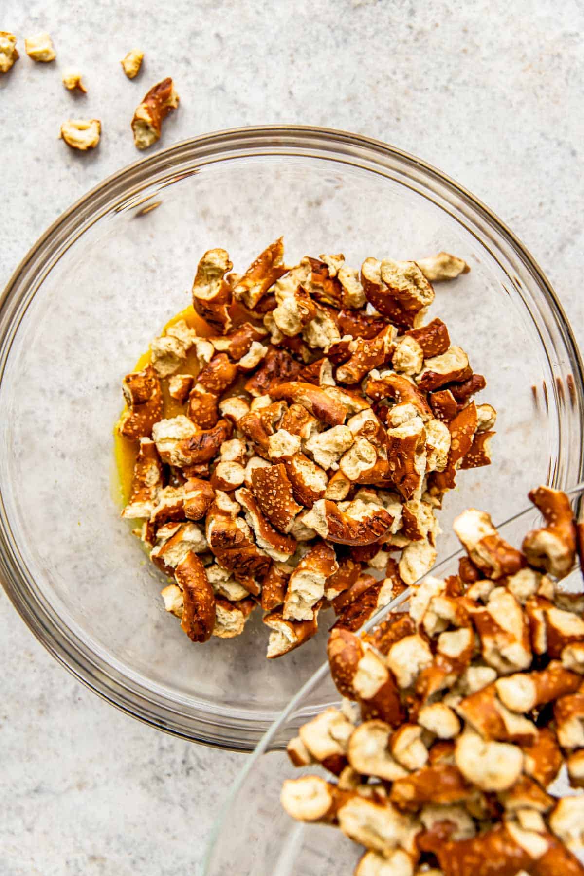 Pretzels are added to a glass bowl. 