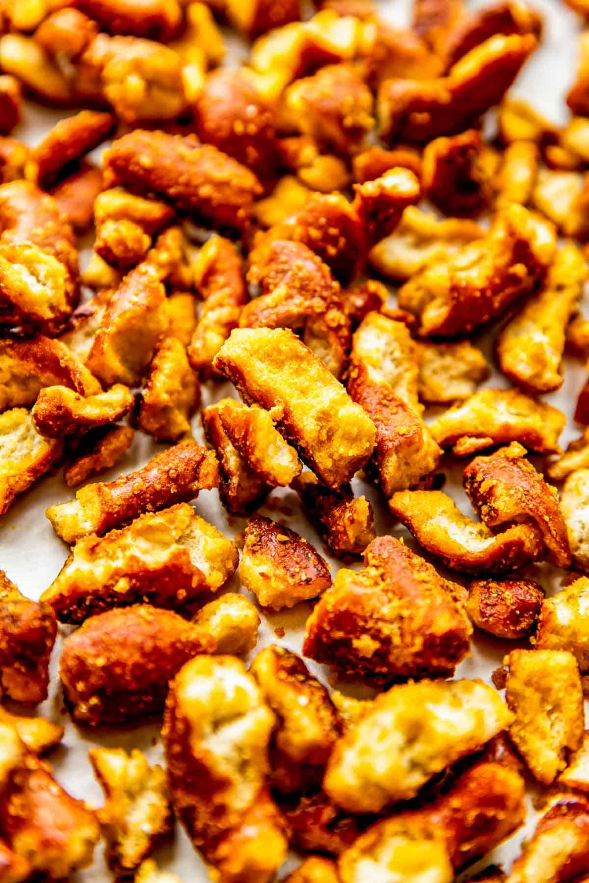 Honey mustard pretzels are spread on a baking sheet. 