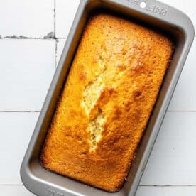 A baked pound cake is presented in a loaf pan.