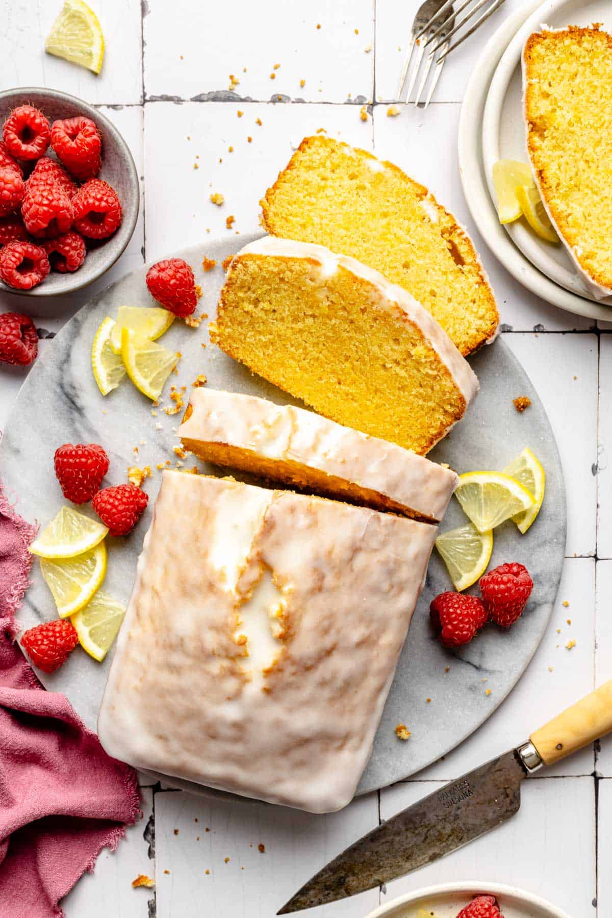 Several slices of pound cake are placed beside the cake.