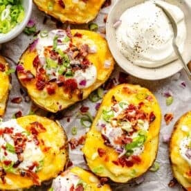 sour cream is placed next to a batch of twice baked potatoes