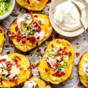 sour cream is placed next to a batch of twice baked potatoes