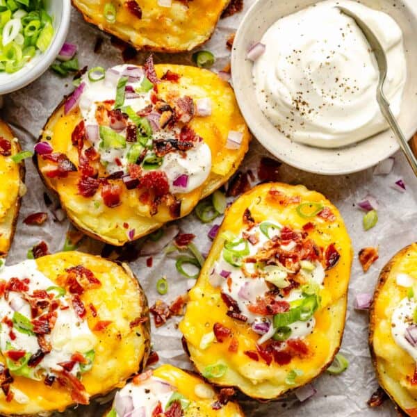 sour cream is placed next to a batch of twice baked potatoes