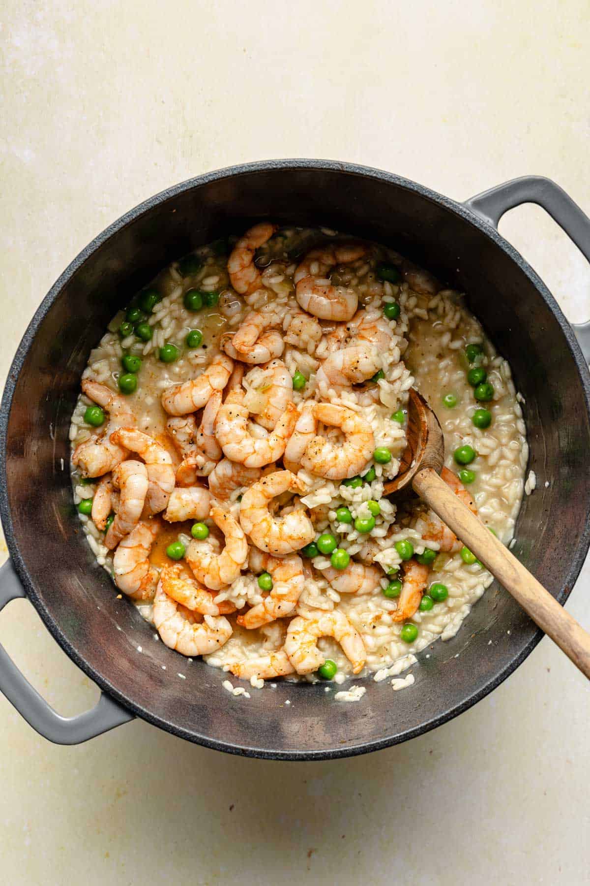 Stirring shrimp and peas into risotto.