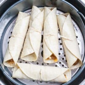 uncooked beef taquitos in the air fryer basket