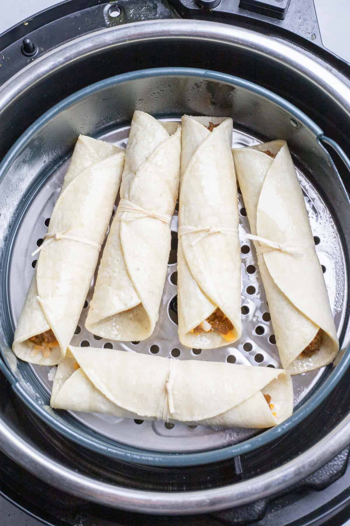 uncooked beef taquitos in the air fryer basket