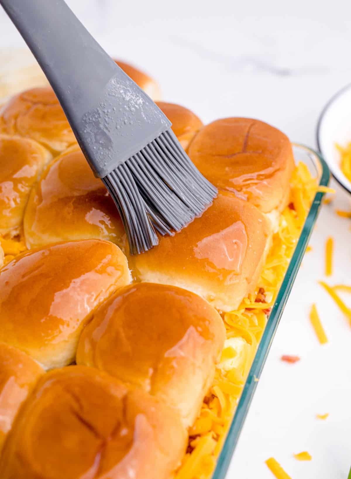 butter spread on top of slider buns with a silicone brush