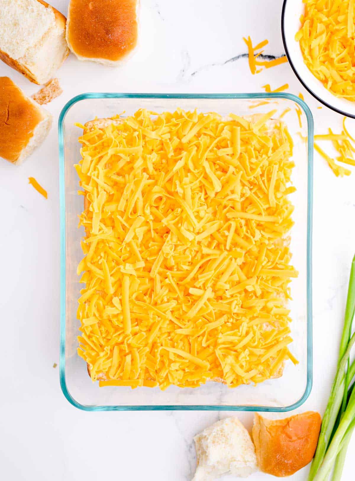 shredded cheddar cheese in a glass baking dish