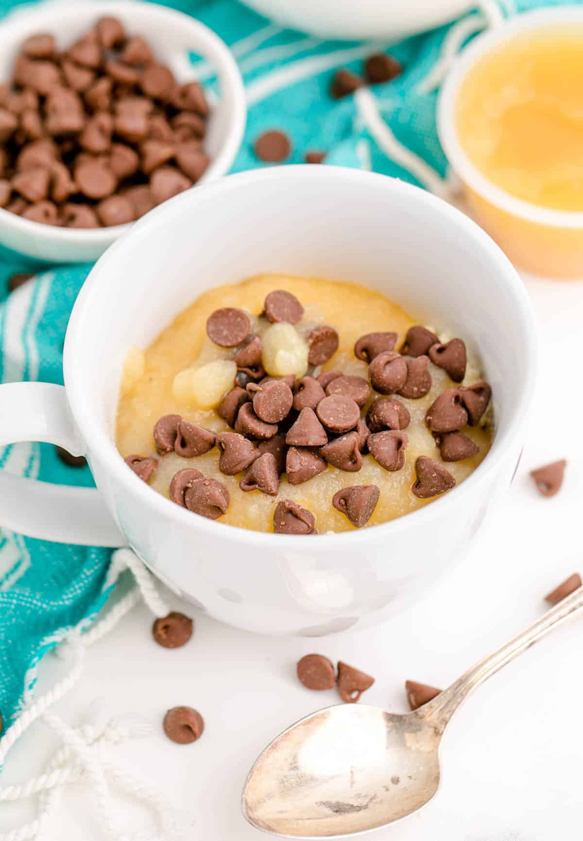 chocolate chips sprinkled on top of apple sauce in a mug