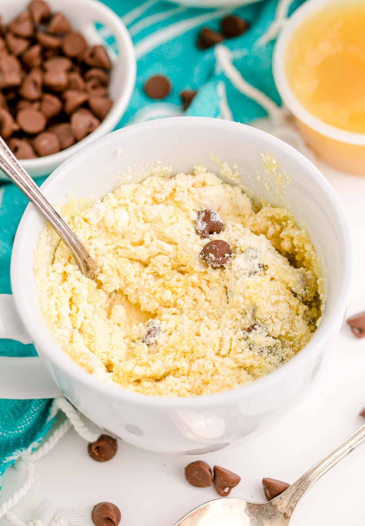 chocolate chips and yellow cake mix is mixed together in a white mug