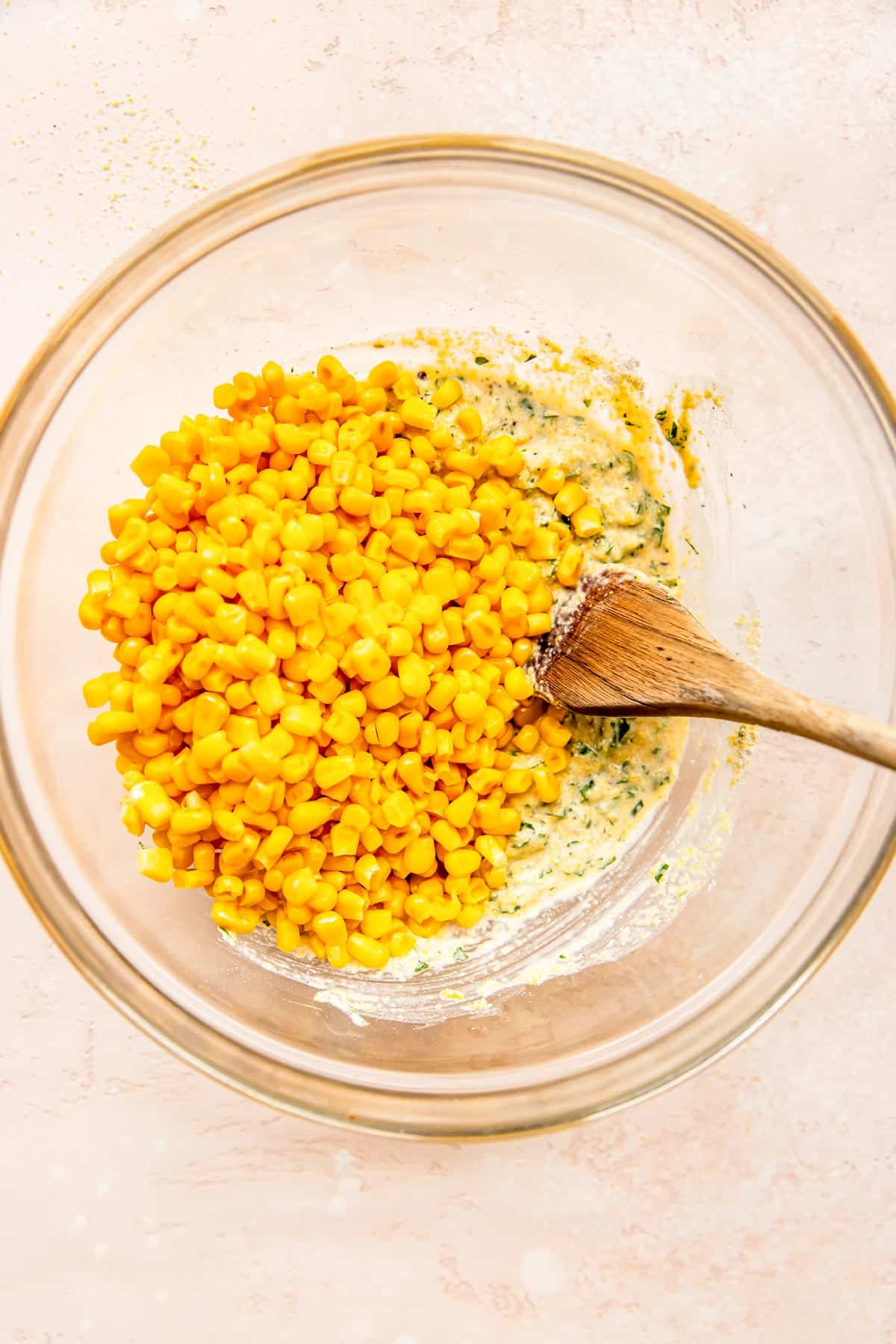 corn kernels being added to the corn fritter batter