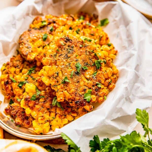 corn fritters on parchment paper with fresh parsley sprinkled on top