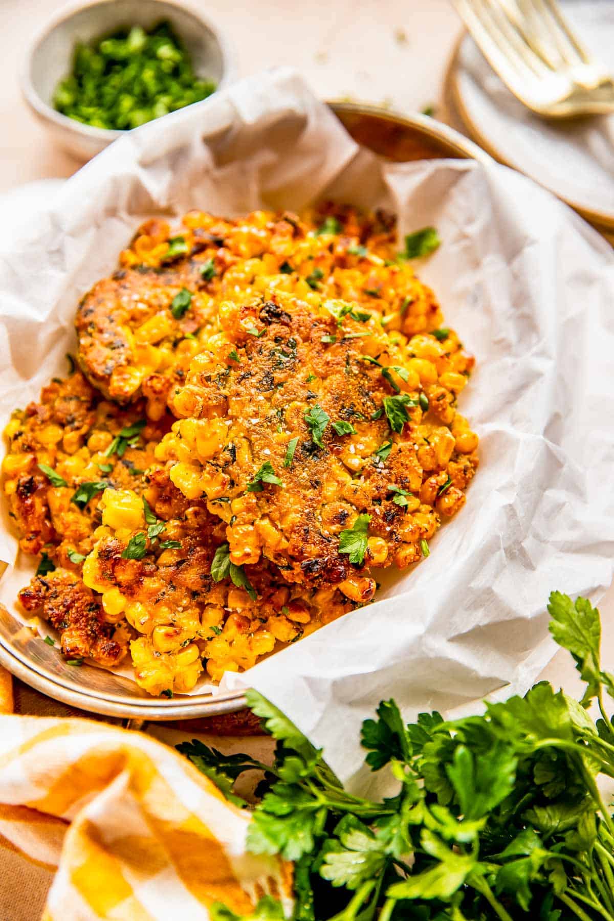 corn fritters on parchment paper with fresh parsley sprinkled on top