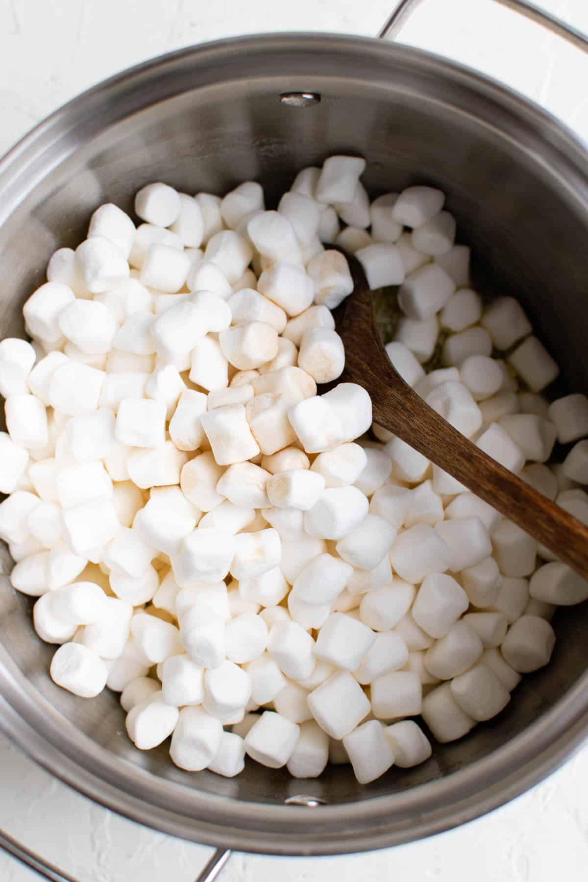mini marshmallows have been added to a pot of melted butter
